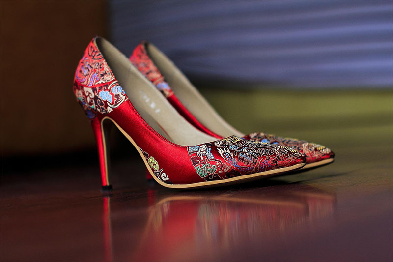 Fancy red designer heels featuring a floral pattern